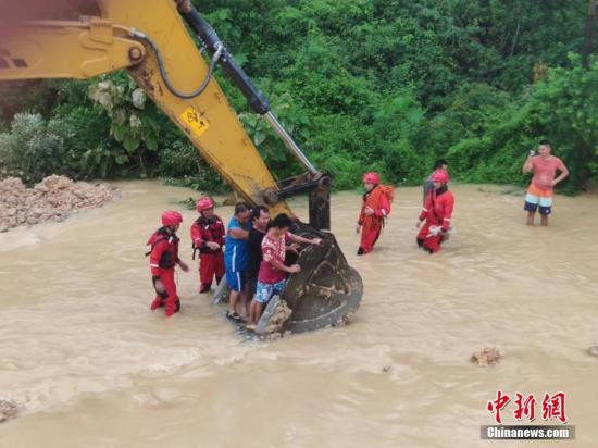 6月16日，因遭遇暴雨袭击，广西沿海多处发生严重内涝，居民被困。当地消防部门接到求助信息后，先后转移被困的居民数十人。图为利用铲车运送被困居民。